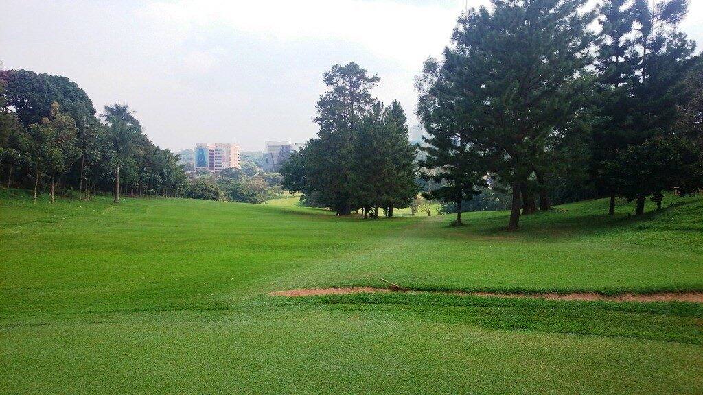 Island green on Lake Victoria at dusk, golfer silhouetted