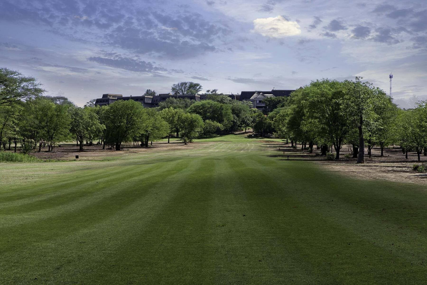 Elephant Hills fairway with the Falls' spray column rising on the horizon