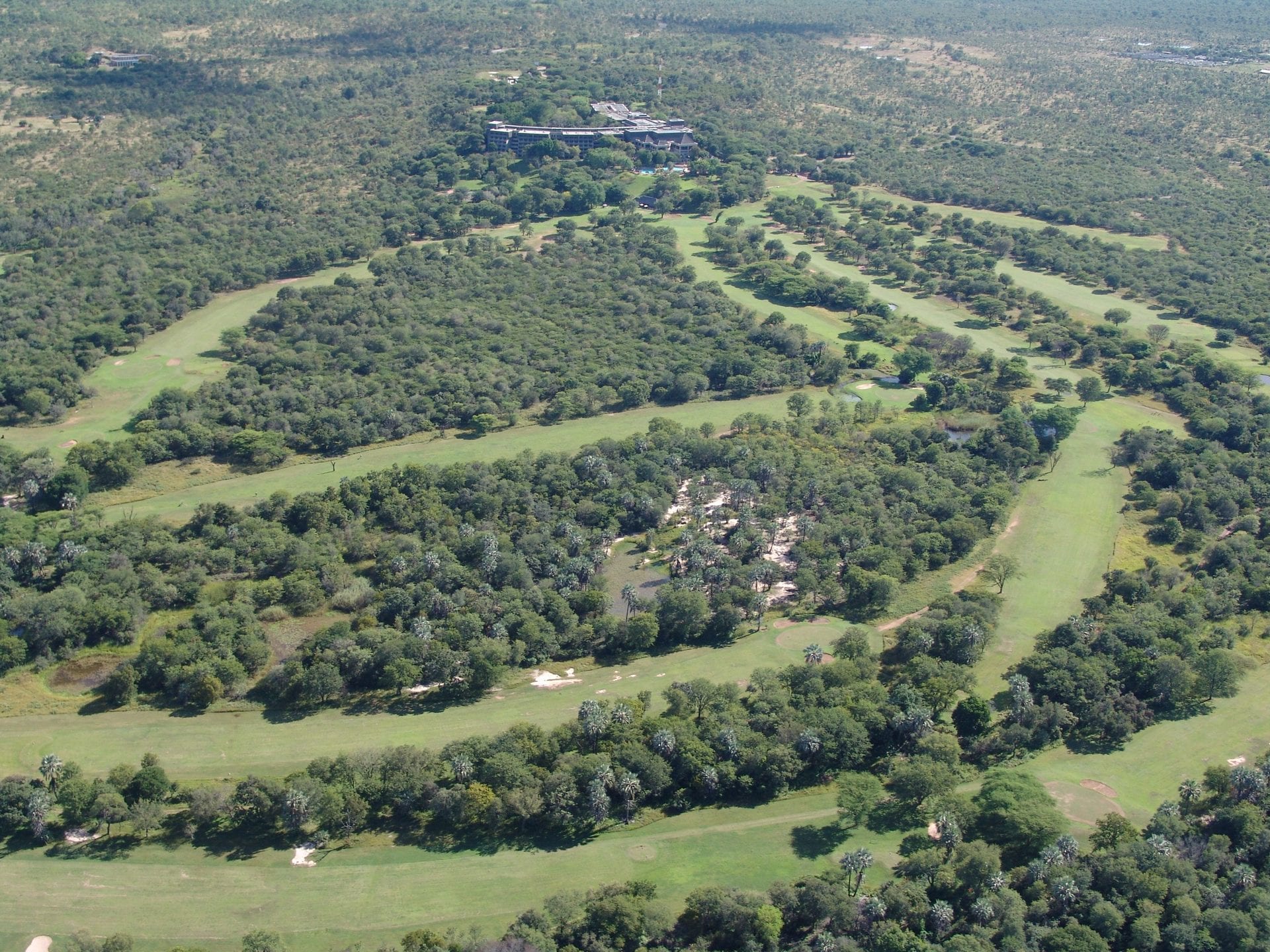 Elephant Hills fairway above the Zambezi with Falls spray beyond